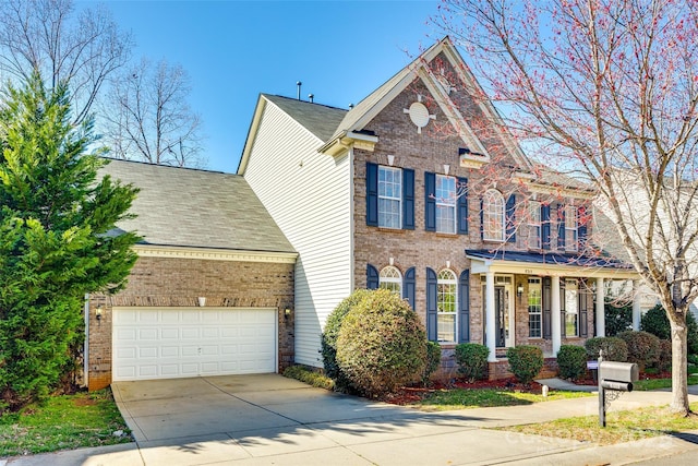 view of front of house with roof with shingles, concrete driveway, and brick siding