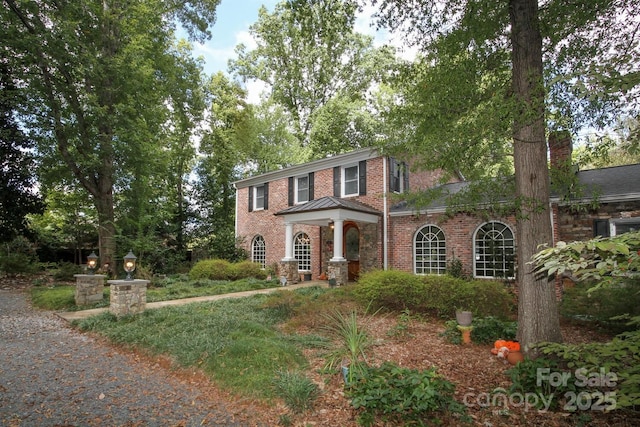 colonial inspired home with brick siding