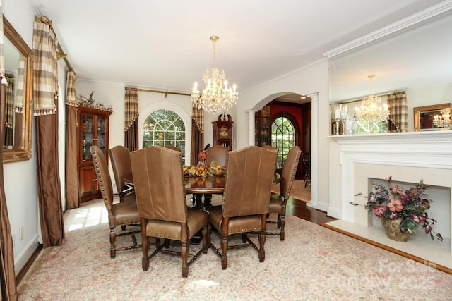 dining room with decorative columns, arched walkways, a chandelier, and crown molding