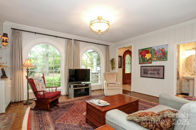 living room with wood finished floors and crown molding