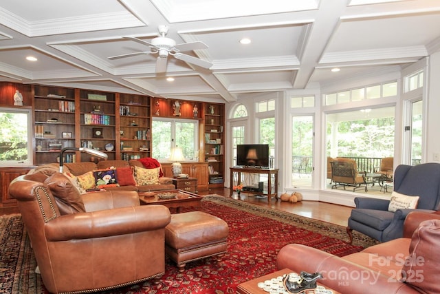 living area featuring plenty of natural light, coffered ceiling, wood finished floors, and a ceiling fan