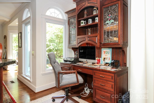 office space featuring baseboards, wood finished floors, and crown molding