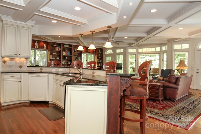 kitchen with dark wood-style floors, a ceiling fan, coffered ceiling, and a sink