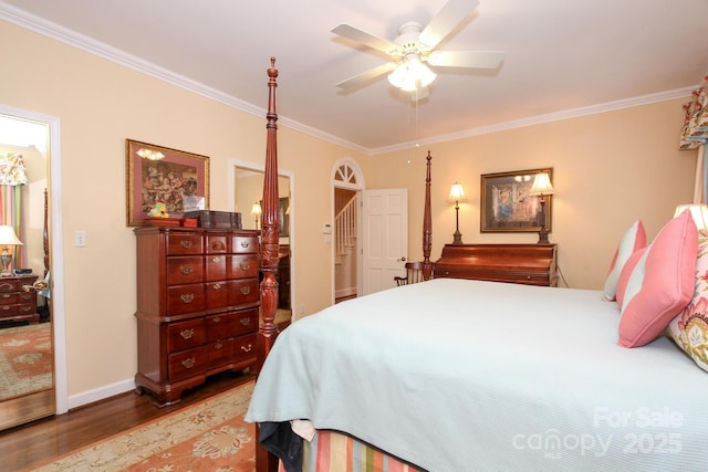 bedroom featuring ornamental molding, baseboards, and wood finished floors