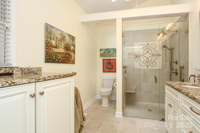 full bath featuring tile patterned flooring, baseboards, toilet, a stall shower, and vanity