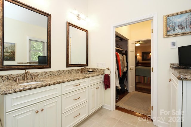 full bath with a sink, a ceiling fan, double vanity, and tile patterned floors