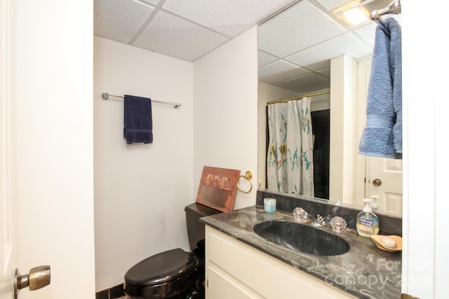 full bath featuring curtained shower, vanity, toilet, and a paneled ceiling