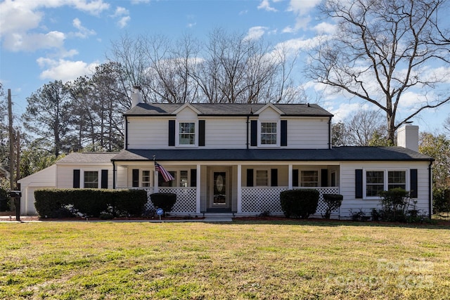 traditional home featuring a front lawn, a porch, and a chimney