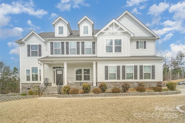 craftsman house featuring stone siding, covered porch, and board and batten siding