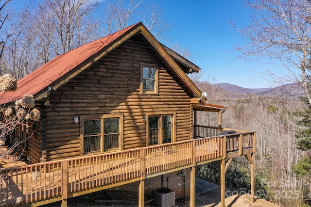 rear view of property featuring a deck with mountain view and log siding