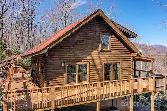 view of side of home with a deck with mountain view, log exterior, and central air condition unit