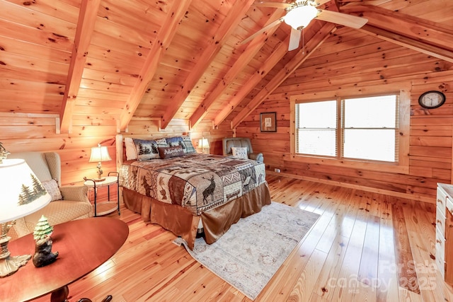 bedroom with vaulted ceiling with beams, wood walls, light wood-type flooring, and wooden ceiling