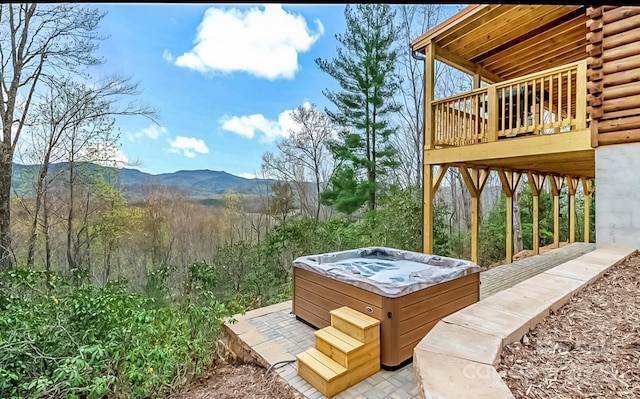 exterior space with a deck with mountain view and a hot tub