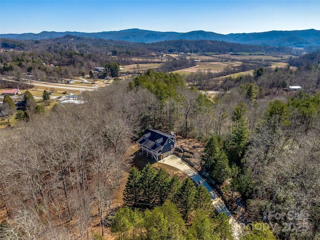 birds eye view of property featuring a wooded view and a mountain view