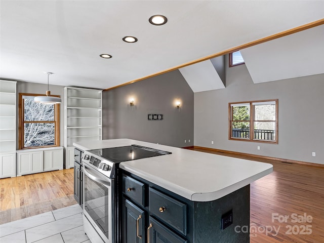 kitchen with light countertops, light wood-style flooring, electric range, vaulted ceiling, and a kitchen island