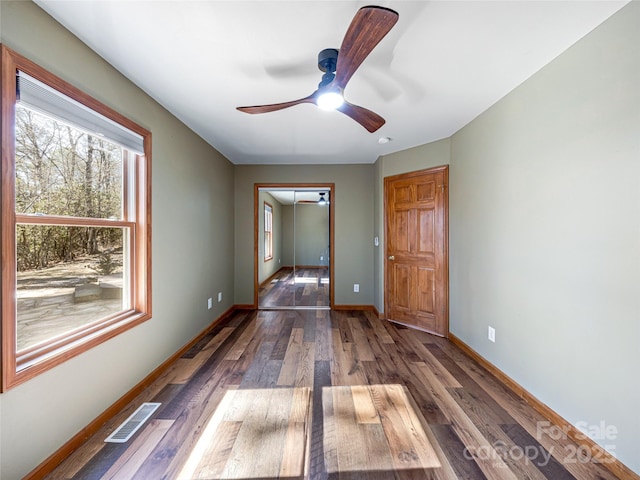 interior space featuring ceiling fan, wood finished floors, visible vents, and baseboards