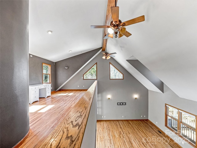 additional living space featuring baseboards, vaulted ceiling, light wood finished floors, and ceiling fan