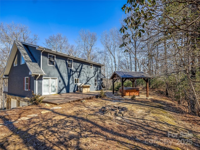 back of house with a gazebo, a patio area, and a hot tub