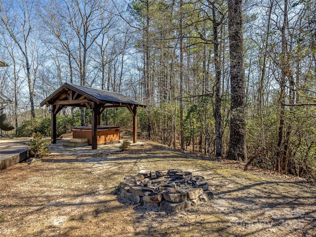 view of yard featuring a fire pit, a gazebo, and a hot tub