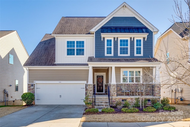 craftsman house featuring a standing seam roof, covered porch, concrete driveway, stone siding, and board and batten siding