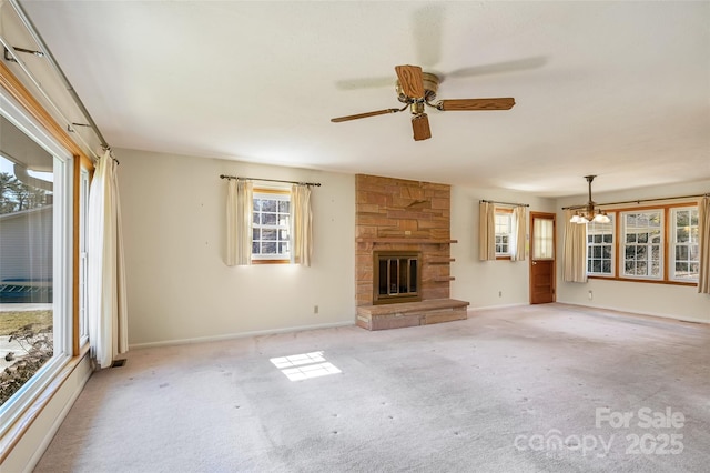 unfurnished living room with a ceiling fan, carpet flooring, a stone fireplace, and baseboards