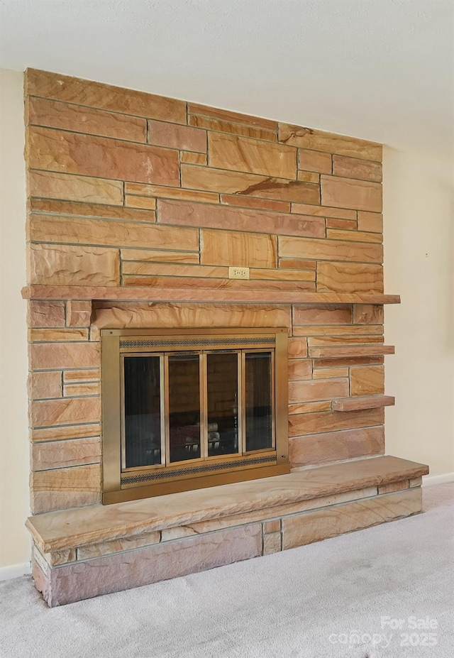 interior details featuring carpet, a fireplace, and baseboards