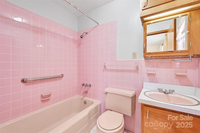 full bathroom featuring wainscoting, toilet, vanity, tile walls, and shower / bathing tub combination