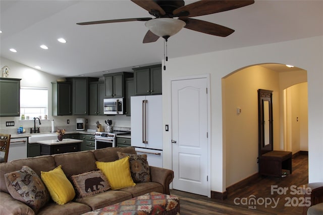 living area with arched walkways, recessed lighting, dark wood-type flooring, a ceiling fan, and vaulted ceiling