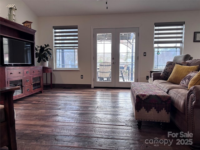 living area with french doors, plenty of natural light, baseboards, and wood finished floors