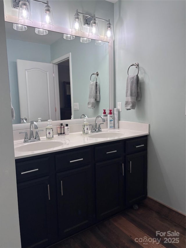 bathroom with double vanity, a sink, and wood finished floors