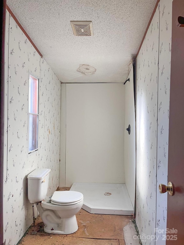 full bath with visible vents, toilet, a shower stall, a textured ceiling, and wallpapered walls