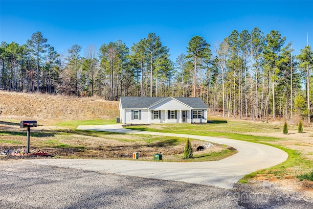 view of front facade with curved driveway and a front lawn