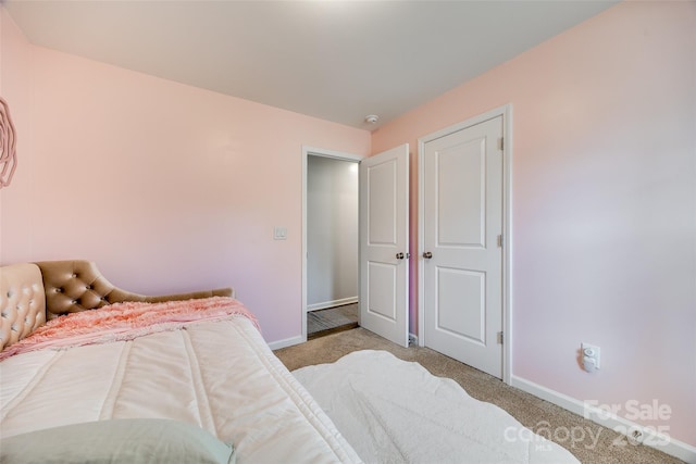 bedroom with light carpet and baseboards