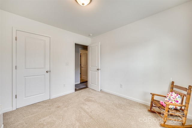 interior space featuring light colored carpet and baseboards