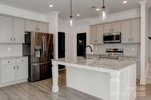 kitchen featuring stainless steel appliances, gray cabinets, visible vents, light wood-style flooring, and a sink