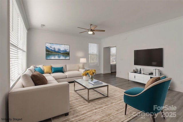 living room with a ceiling fan, crown molding, and wood finished floors