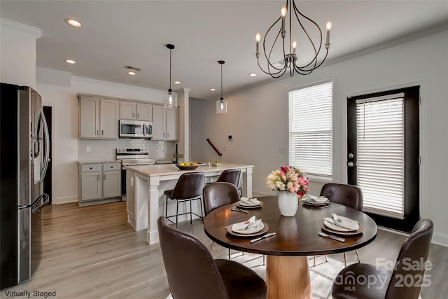 dining room with light wood finished floors, visible vents, crown molding, and recessed lighting