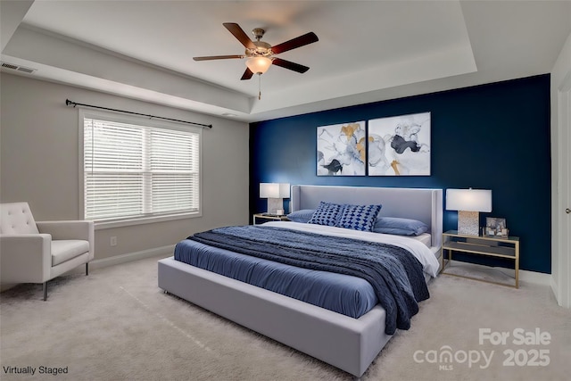 bedroom featuring carpet, a raised ceiling, visible vents, ceiling fan, and baseboards