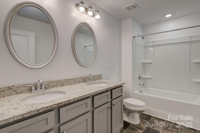 bathroom featuring visible vents, a sink, toilet, and double vanity