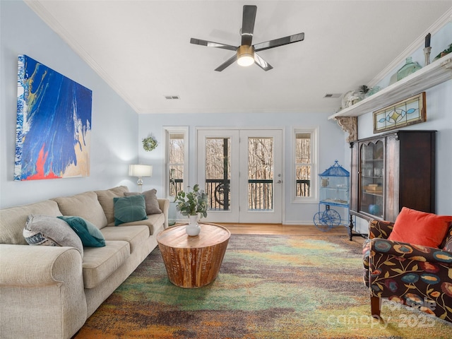 living room featuring a ceiling fan, wood finished floors, visible vents, and crown molding