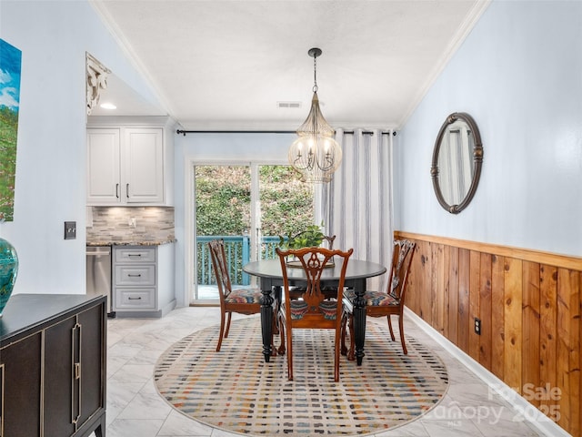 dining space featuring crown molding, marble finish floor, a wainscoted wall, and wooden walls