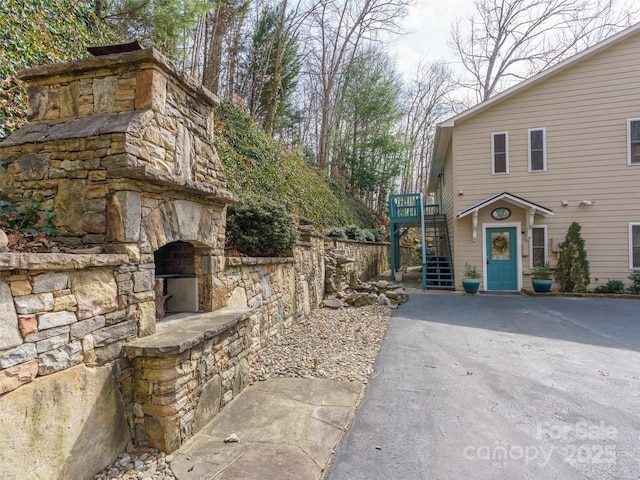 view of side of property featuring stairs and a fireplace