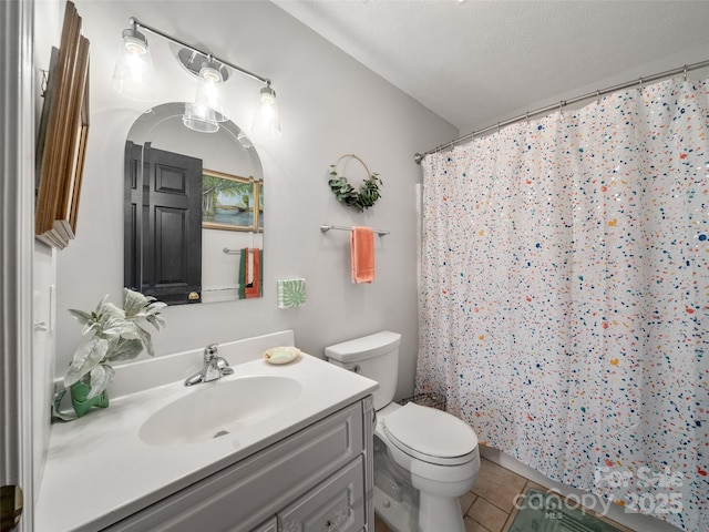 bathroom with a textured ceiling, curtained shower, tile patterned flooring, toilet, and vanity