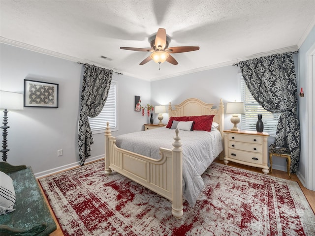 bedroom with light wood-type flooring, visible vents, crown molding, and a textured ceiling