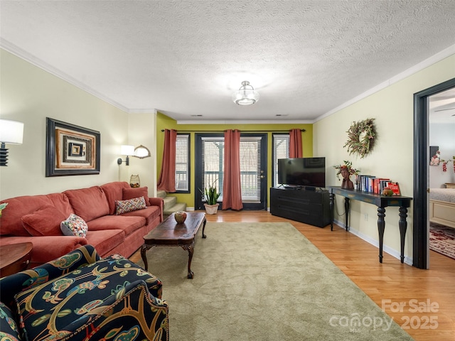 living room with a textured ceiling, ornamental molding, and wood finished floors