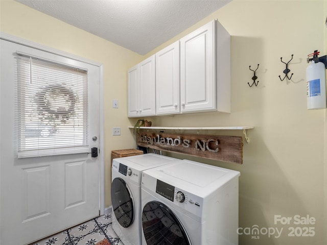 laundry area with washer and dryer, cabinet space, and a textured ceiling