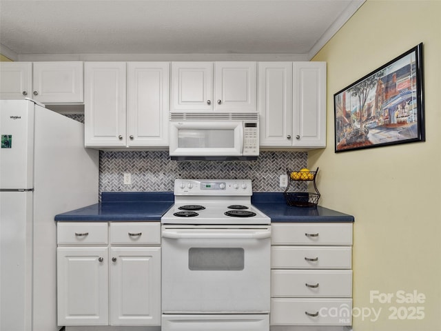 kitchen with white appliances, dark countertops, decorative backsplash, and white cabinets