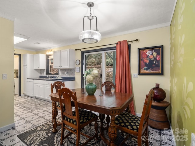 dining space with ornamental molding and baseboards