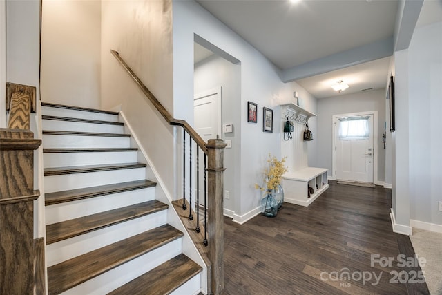 foyer entrance with stairs, baseboards, and wood finished floors