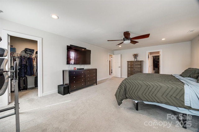 carpeted bedroom with a walk in closet, a closet, and recessed lighting